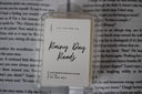 A wax melt pack with the label 'Rainy Day Reads' placed on an open book background
