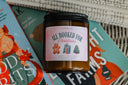 All Booked for Christmas candle with wooden wick on festive books and open pages
