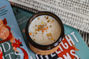 Bourbon & Butterscotch holiday candle with festive sprinkle design and wooden wick