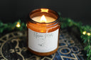 Elysian mates booked-themed candle in amber jar with wood wick burning