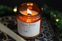 elysian mates themed candle in amber jar with wood wick burning