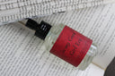 'In my Good Girl Era' perfume bottle with red label on a book