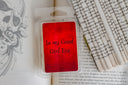 Red wax melt package labeled 'In my Good Girl Era' on a book with text and a skull design.