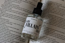 Bottle of 'My Villain Era' perfume on an open book