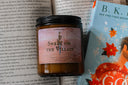 Romantasy-themed 'Sweet on the Villain' candle with a book in the background