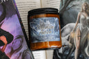 Licensed Tessalyn Ausra book candle in front of fantasy book with ethereal woman in flowing gown