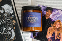 Candle with 'Theon' label on a book and romance illustration