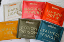 A collection of tea sachets with various flavors, each in different colored packaging, labeled with fantasy-themed names such as 'Potion or Poison', 'Tavern Brew', 'Magical Powers', 'Dark vs. Light', 'Dragon Fire', and 'Feathers & Fangs'.