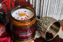 top view of medra pendragon candle displaying the wood wick, wax, and red confetti